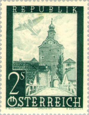 Colnect-136-175-Airplane-over-city-tower-in-Gm-uuml-nd-K-auml-rnten.jpg